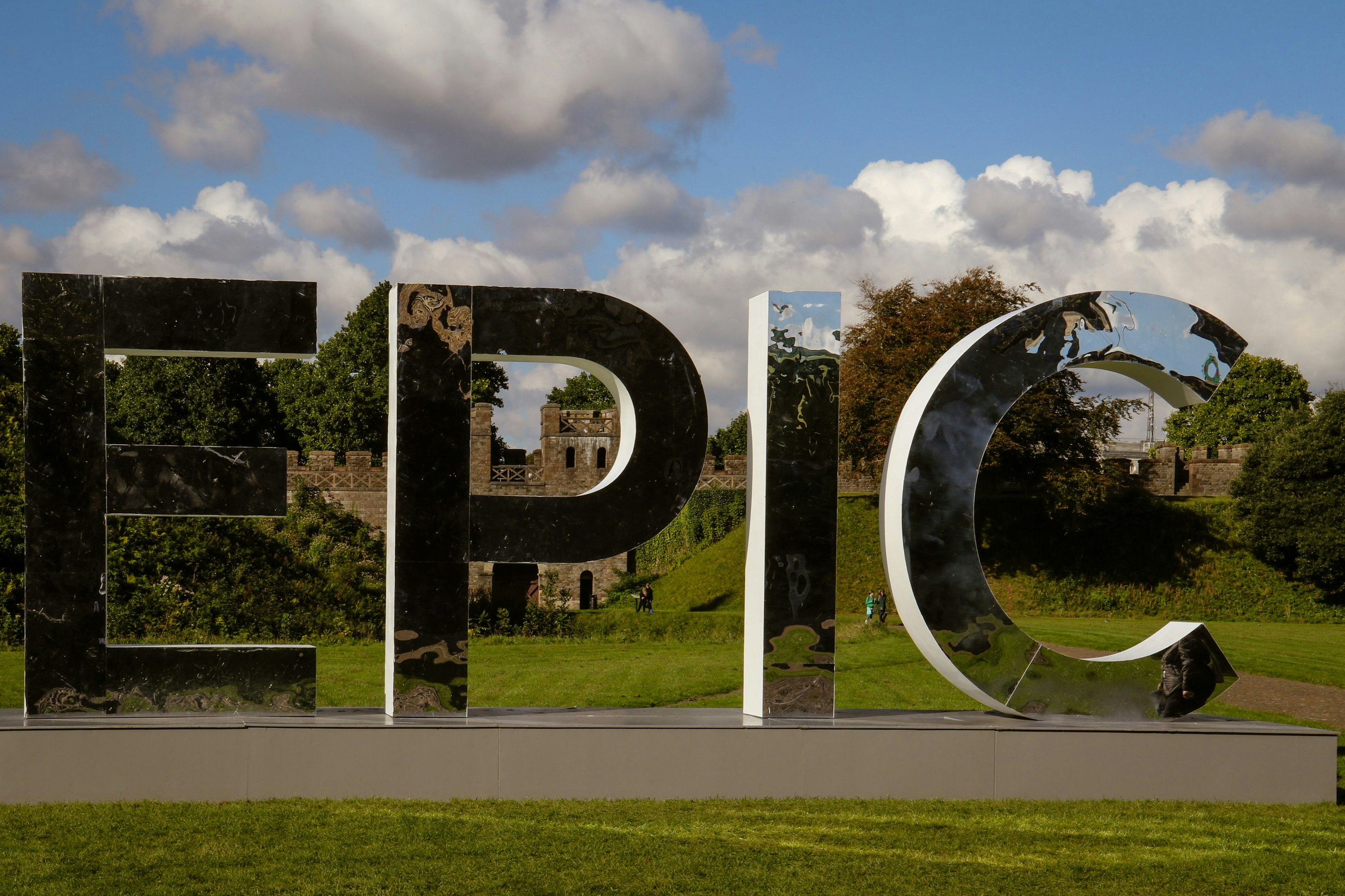 round mirror with reflection of man standing on the ground